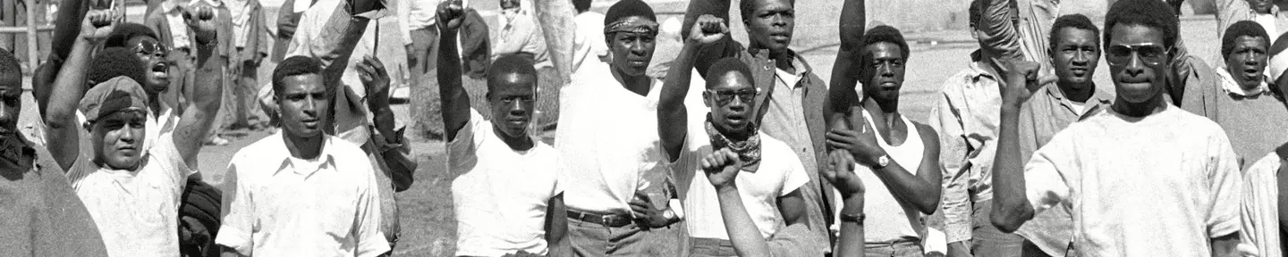 Prisoners raise their fists during the Attica uprising.